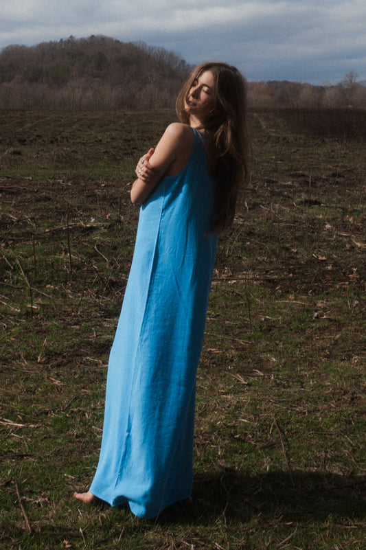 Model wearing long blue Cupro Dress while looking back