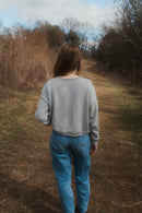 model standing showing back of grey true knit cotton sweater.