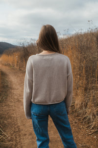 model standing showing back of oat true knit cotton sweater.